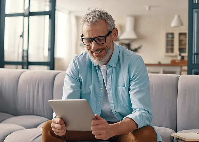 Grey haired man looking at tablet computer