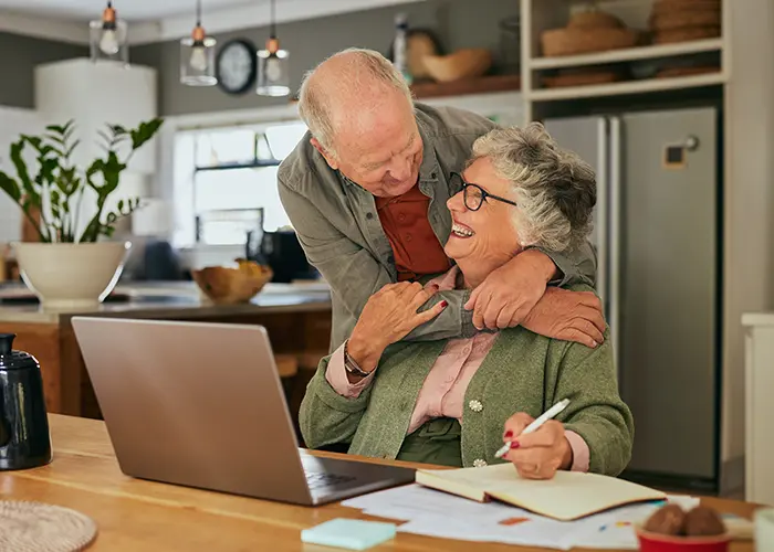 Older couple sitting at table planning for retirement