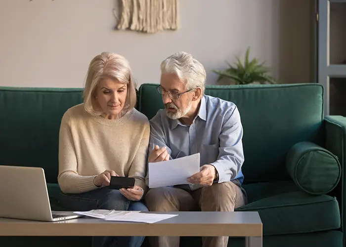 Older couple sitting on couch planning for retirement