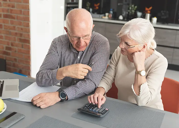 Older couple with calculator looking at financial statement