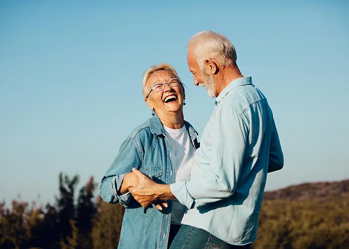 Older couple holding hands and laughing