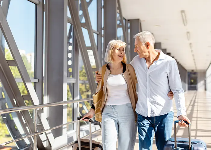 Older couple with suitcases walking through airport